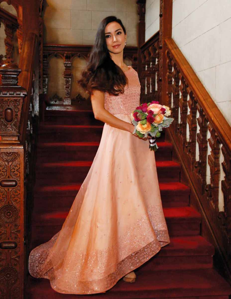 bridesmaid with flowers on red staircase wood bannister