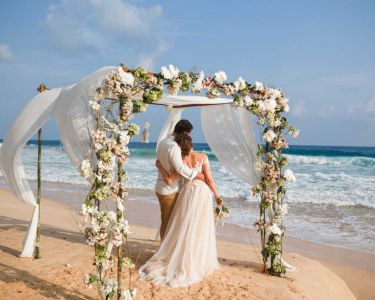bride-groom-hugging-onbeach-looking-at-ocean