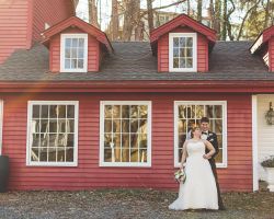 inn-red-building-bride-groom-embrace-outdoor-wedding-venue-millrace-pond